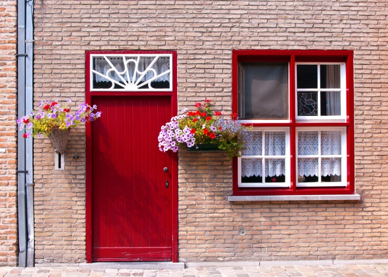 a large brick building with a red front door and window