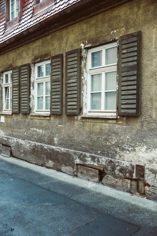 three windows with shutters on each side of the building