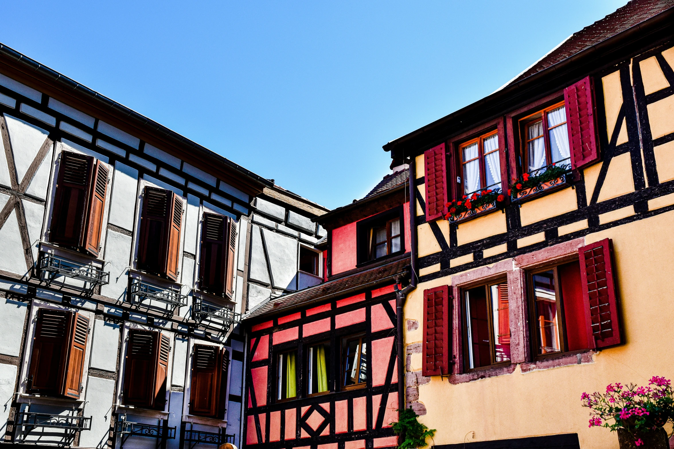 old buildings with some flowers and red windows