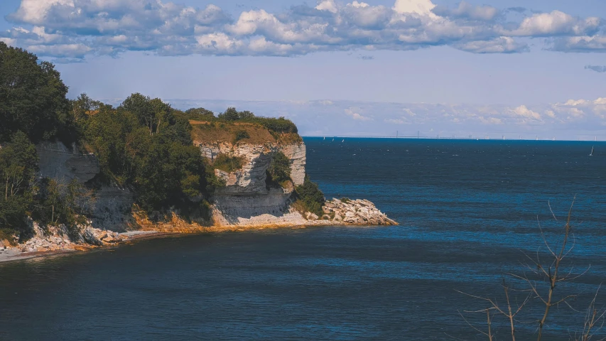 an island with rocks and trees and some clouds