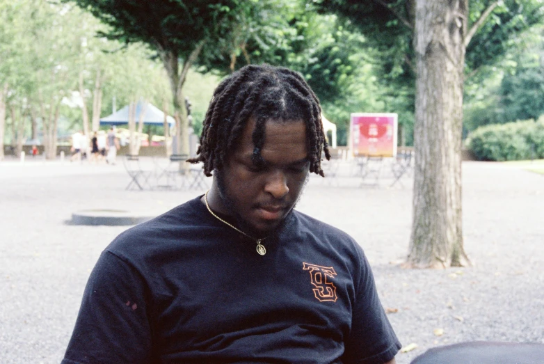 a man with dreadlocks on in the street holding a frisbee