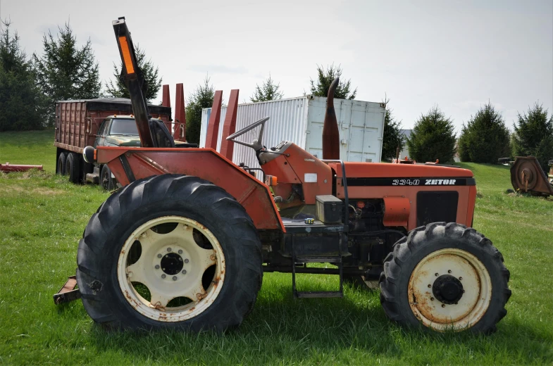 an old tractor is parked in the grass