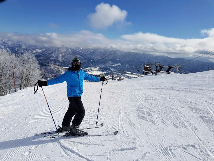 a man in blue jacket skiing down a slope