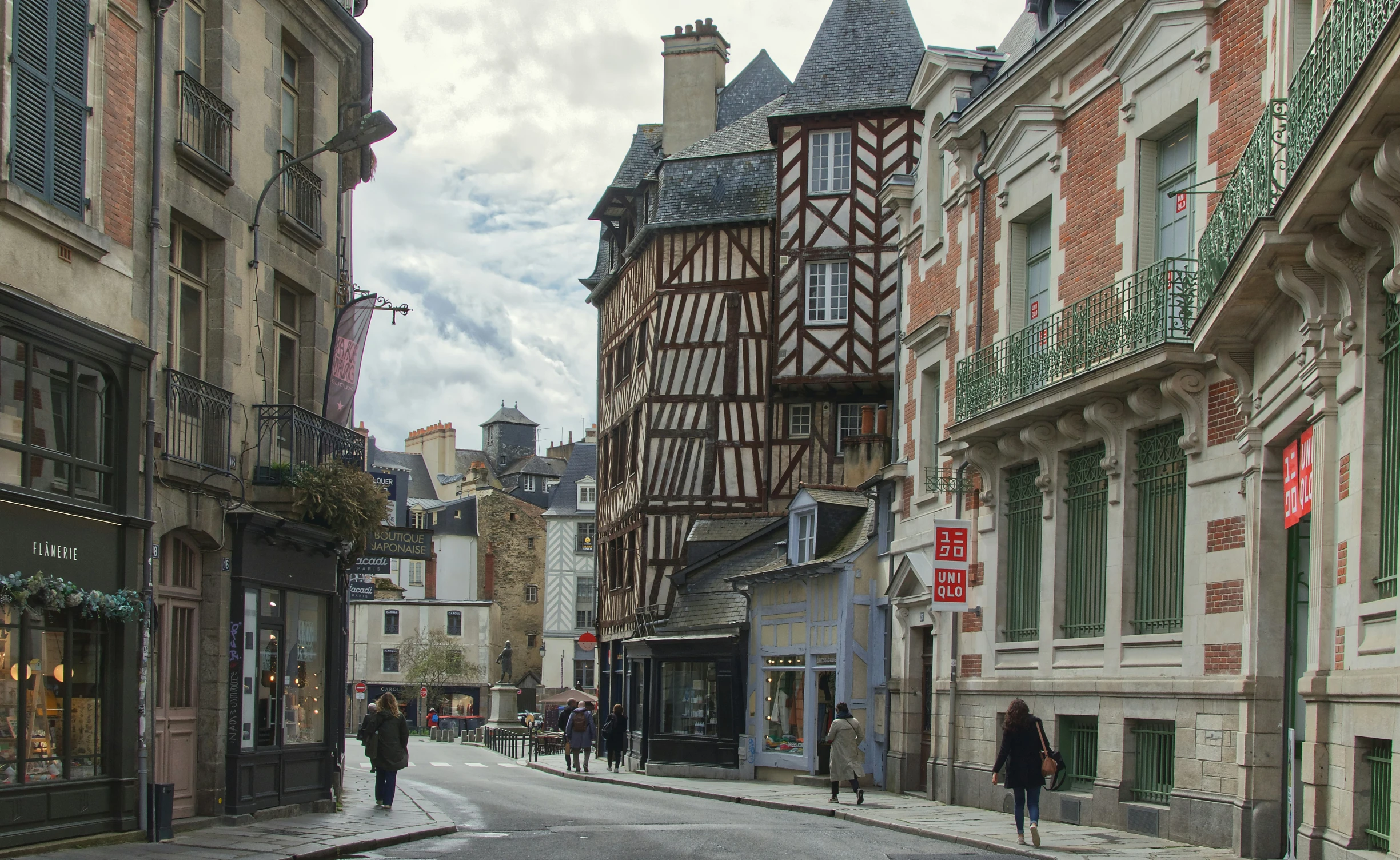 a street view of people walking down an empty city street