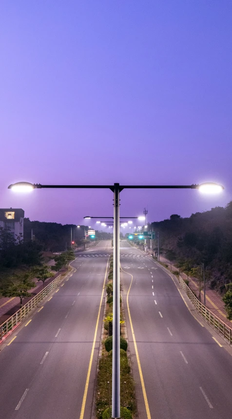 empty highway surrounded by traffic lights at night