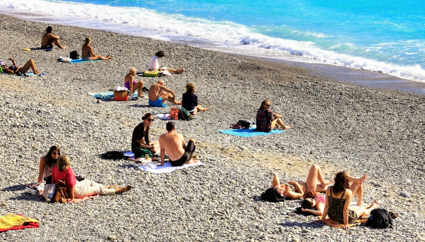 a group of people on a beach sitting under umbrellas