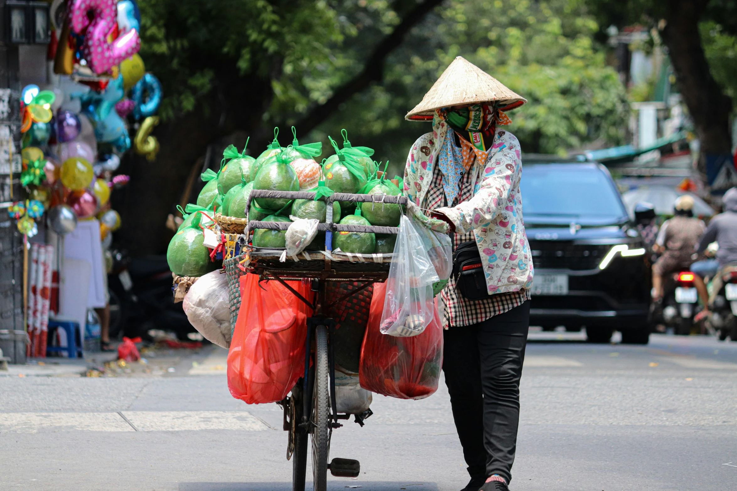 a woman hing a cart with several bags of groceries on it