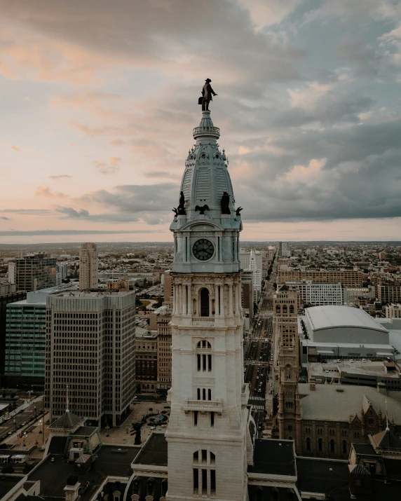 a white clock tower sitting above city in the daytime