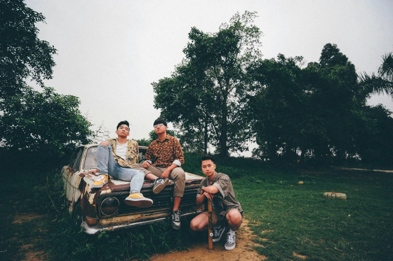 four people are sitting on a couch in a field