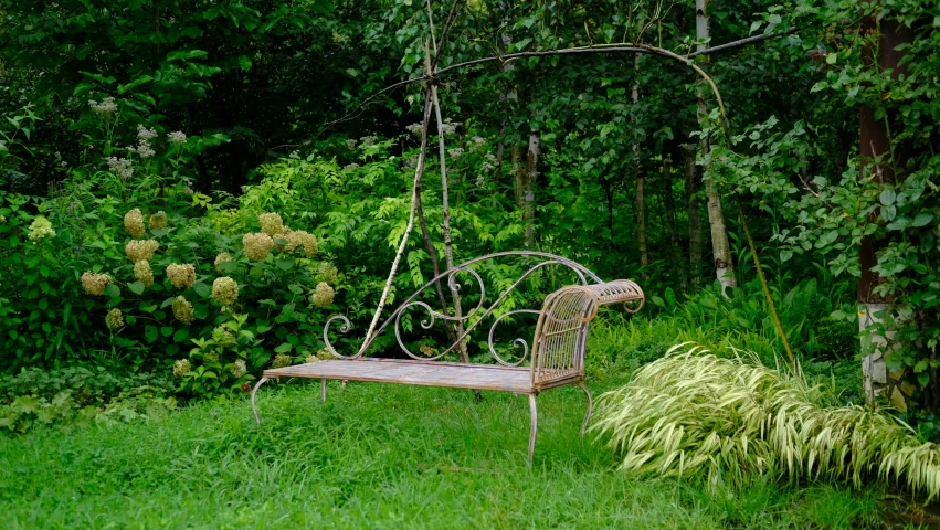 a metal bench surrounded by a bunch of trees