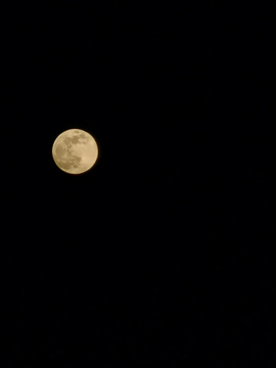 an airplane is flying under the moon at night