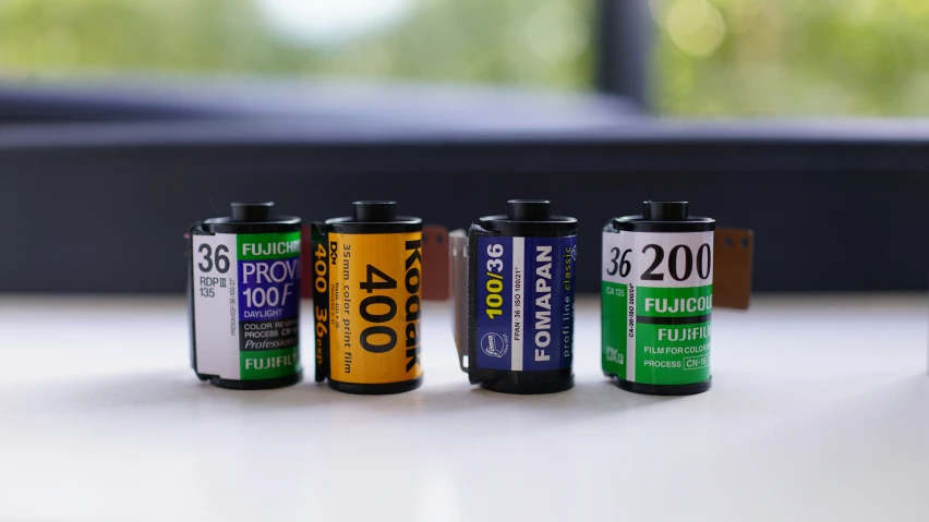 four batteries sitting on a table in front of a window