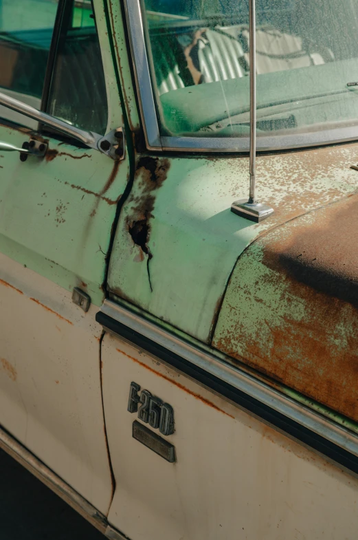 a rusted out and rusty car with the hood up