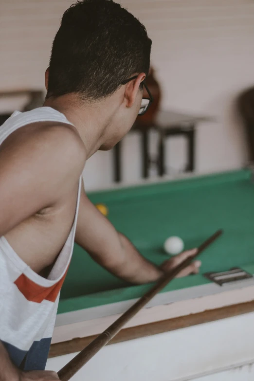 a man playing a game of pool with some cues