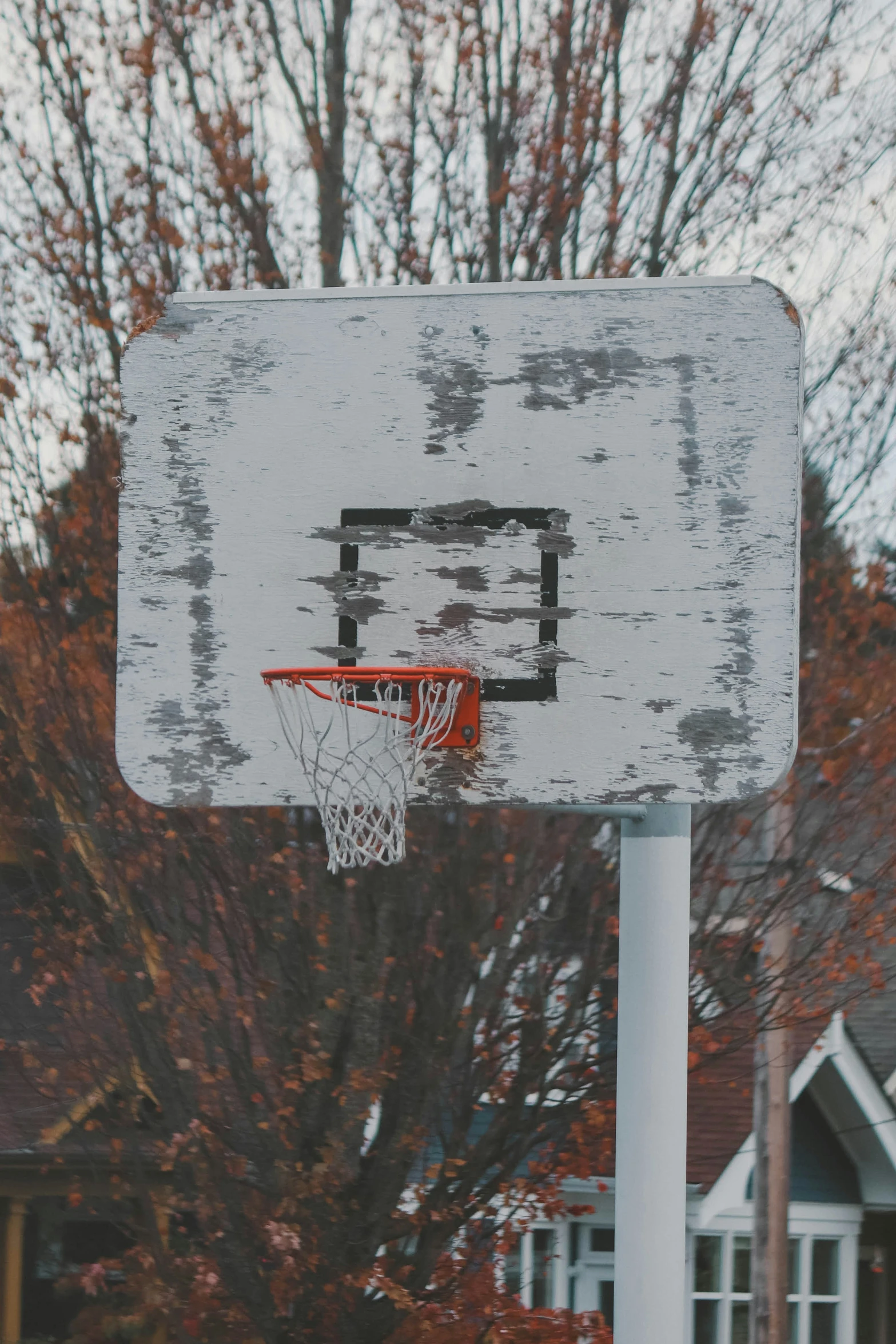 a white wood basketball goal with an orange basket