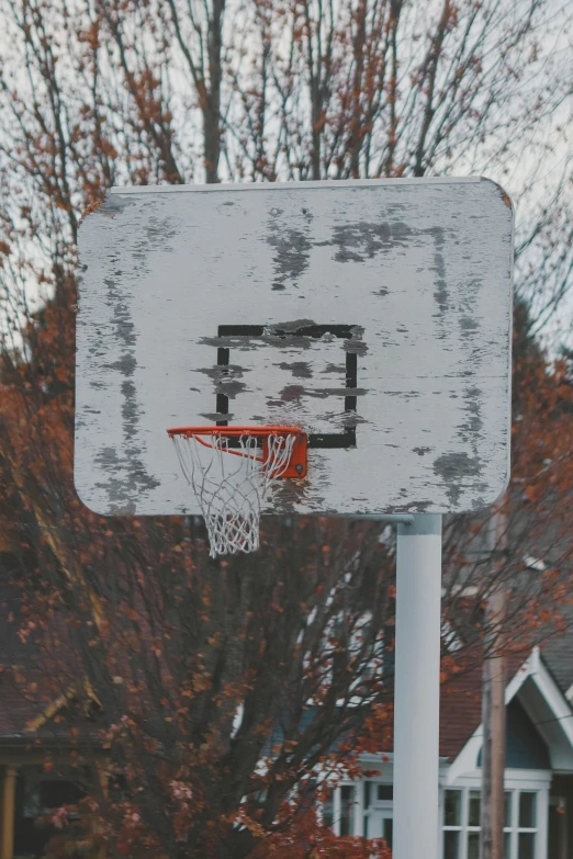 a white wood basketball goal with an orange basket