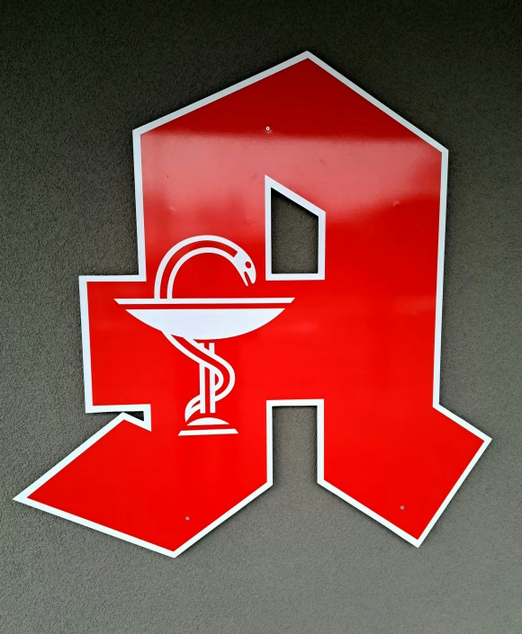 a large hospital symbol is hanging on the wall