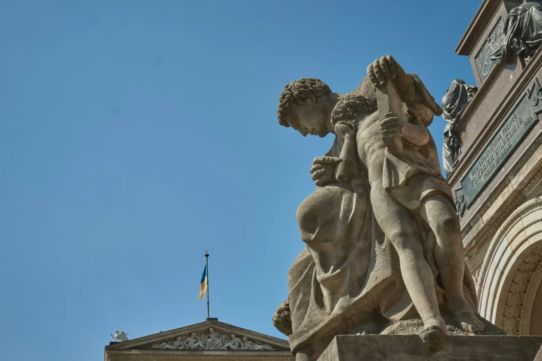 a statue is against a blue sky in a city