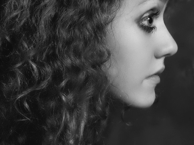 a woman with wavy hair with her hand in her pocket