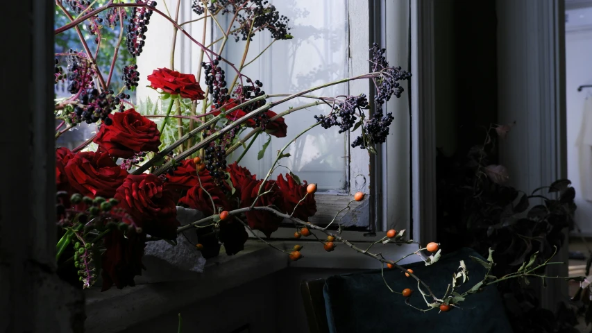 a vase of flowers is sitting on the windowsill