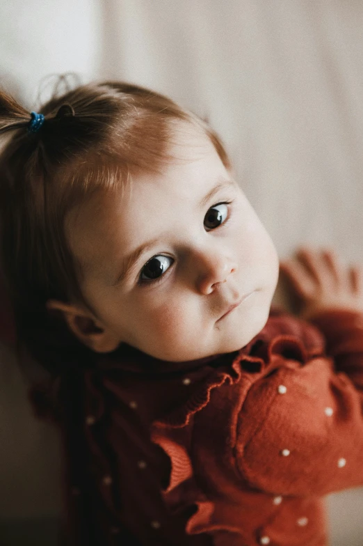 a little girl wearing a red shirt posing for the camera