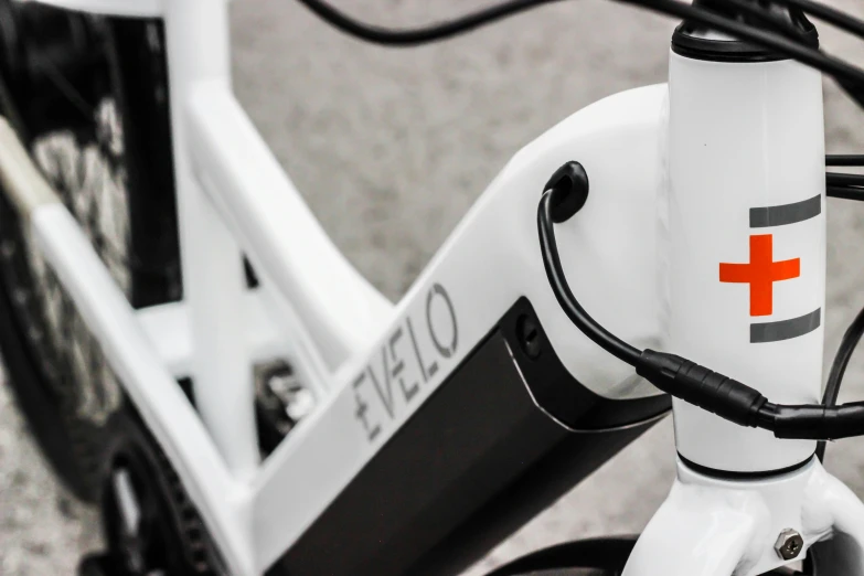 a close up of the top section of a bicycle with a red cross