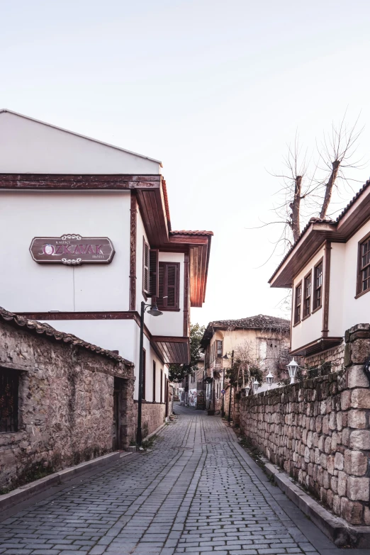 the alley of the old village has a cobblestone stone and brick sidewalk that stretches across both sides