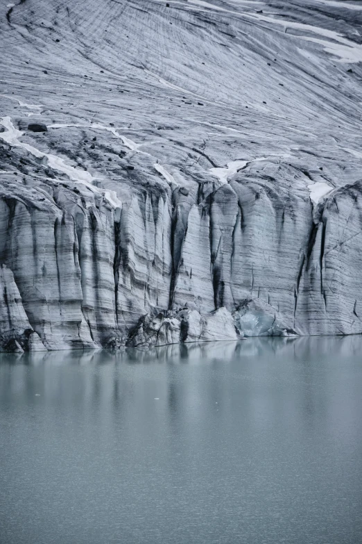 large ice age rock face at the edge of a body of water