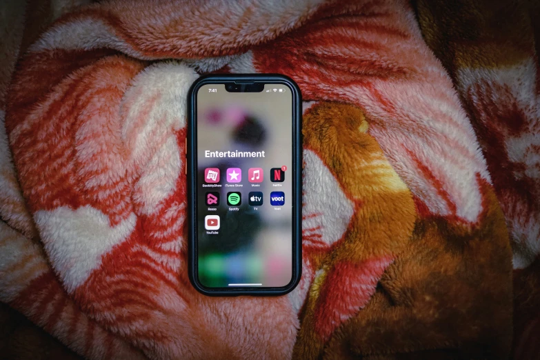 a cellphone sitting on a fur covered blanket