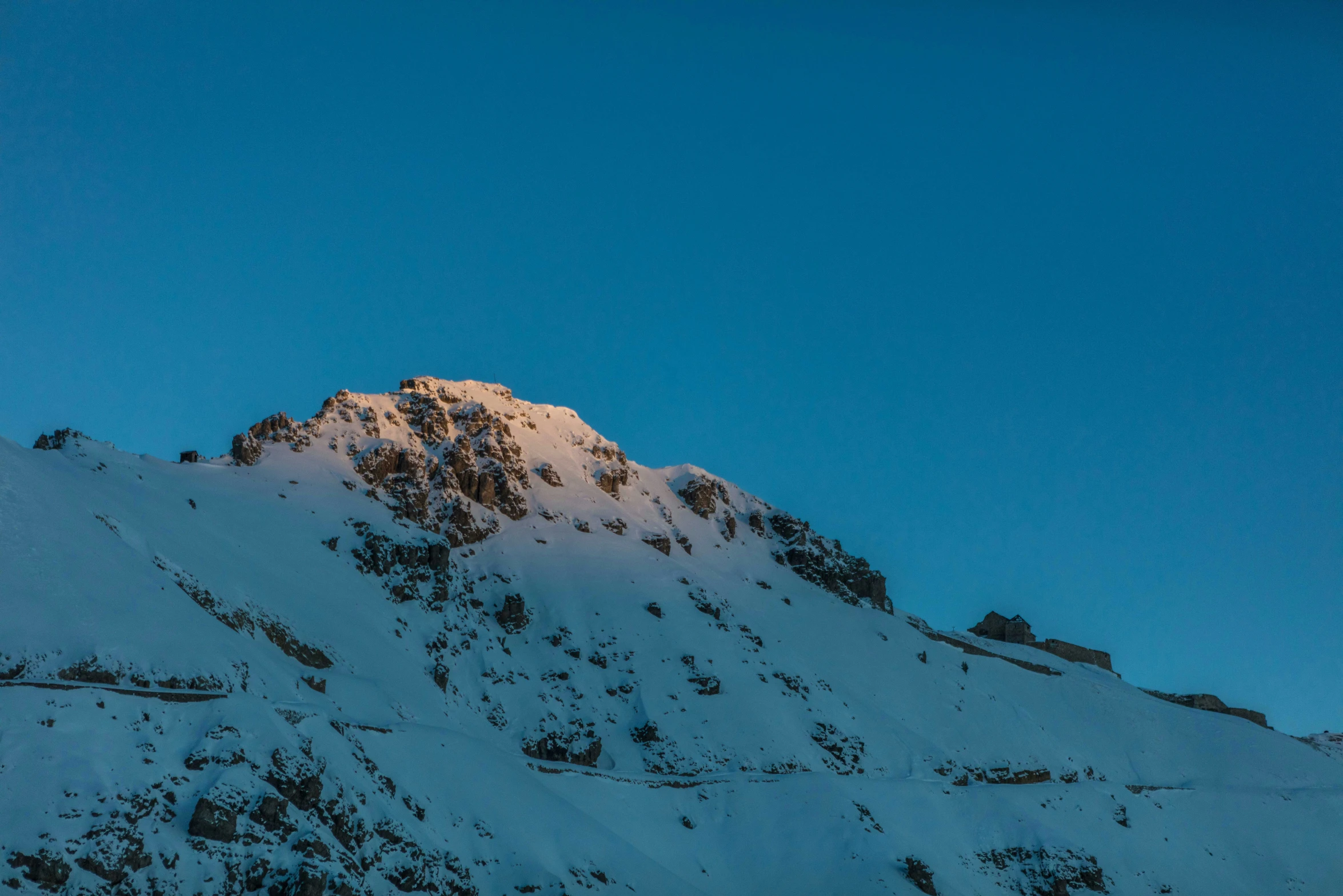 a snowboarder is standing on the snow covered side of a mountain