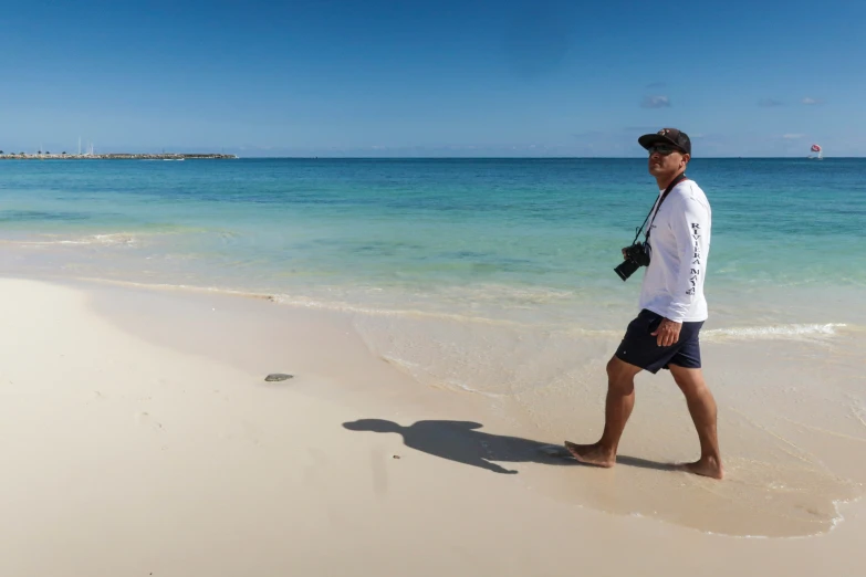 a man walks on a beach toward the ocean