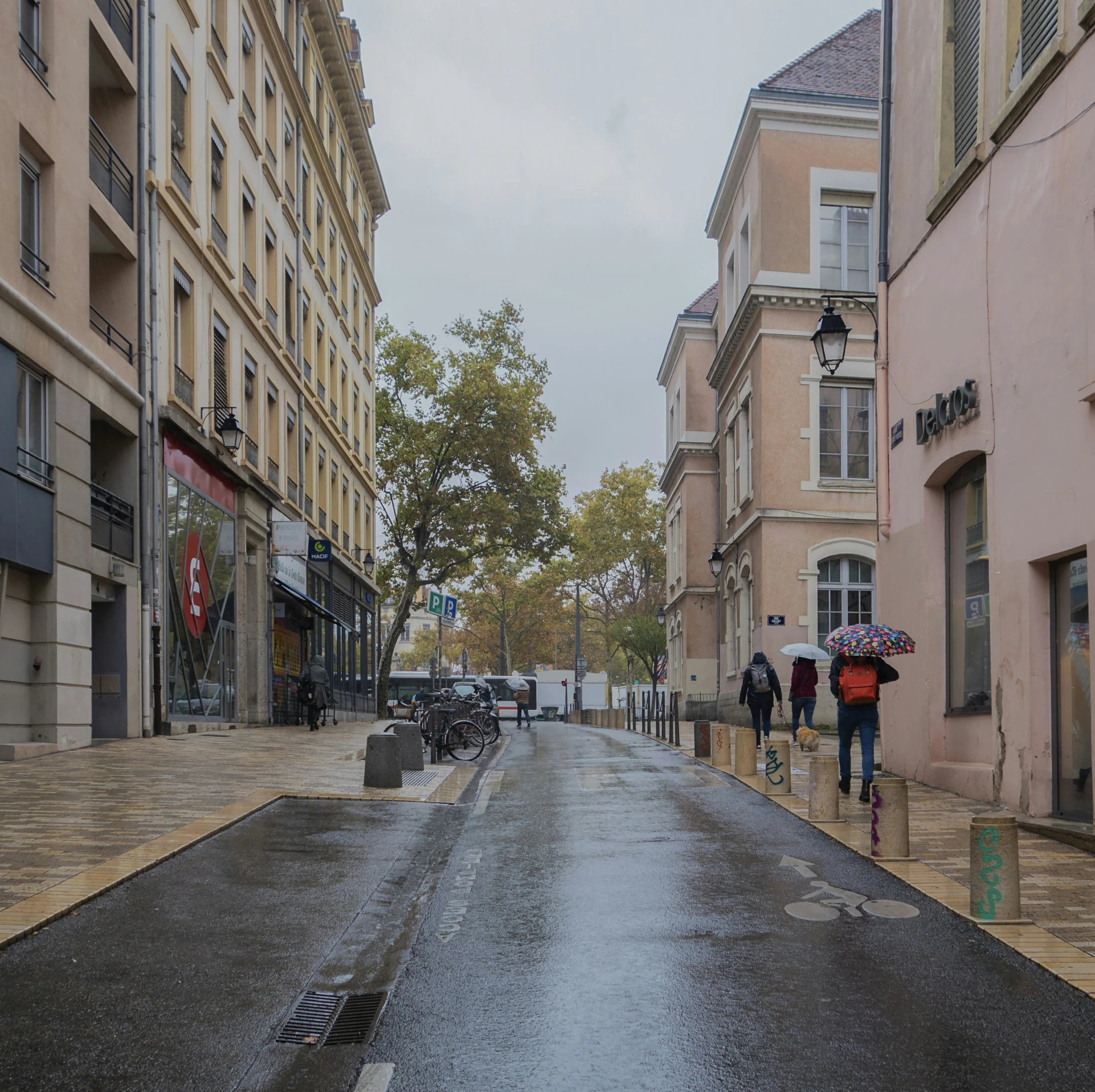 pedestrians holding umbrellas walking down the street in the rain