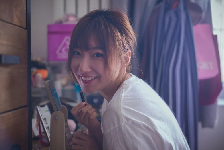 an asian woman in white shirt brushing her teeth