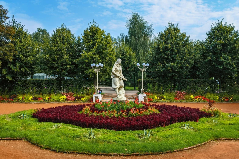 an ornamental garden with plants, lights and a statue