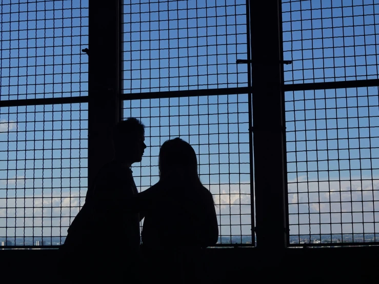 a man and a woman near a glass window