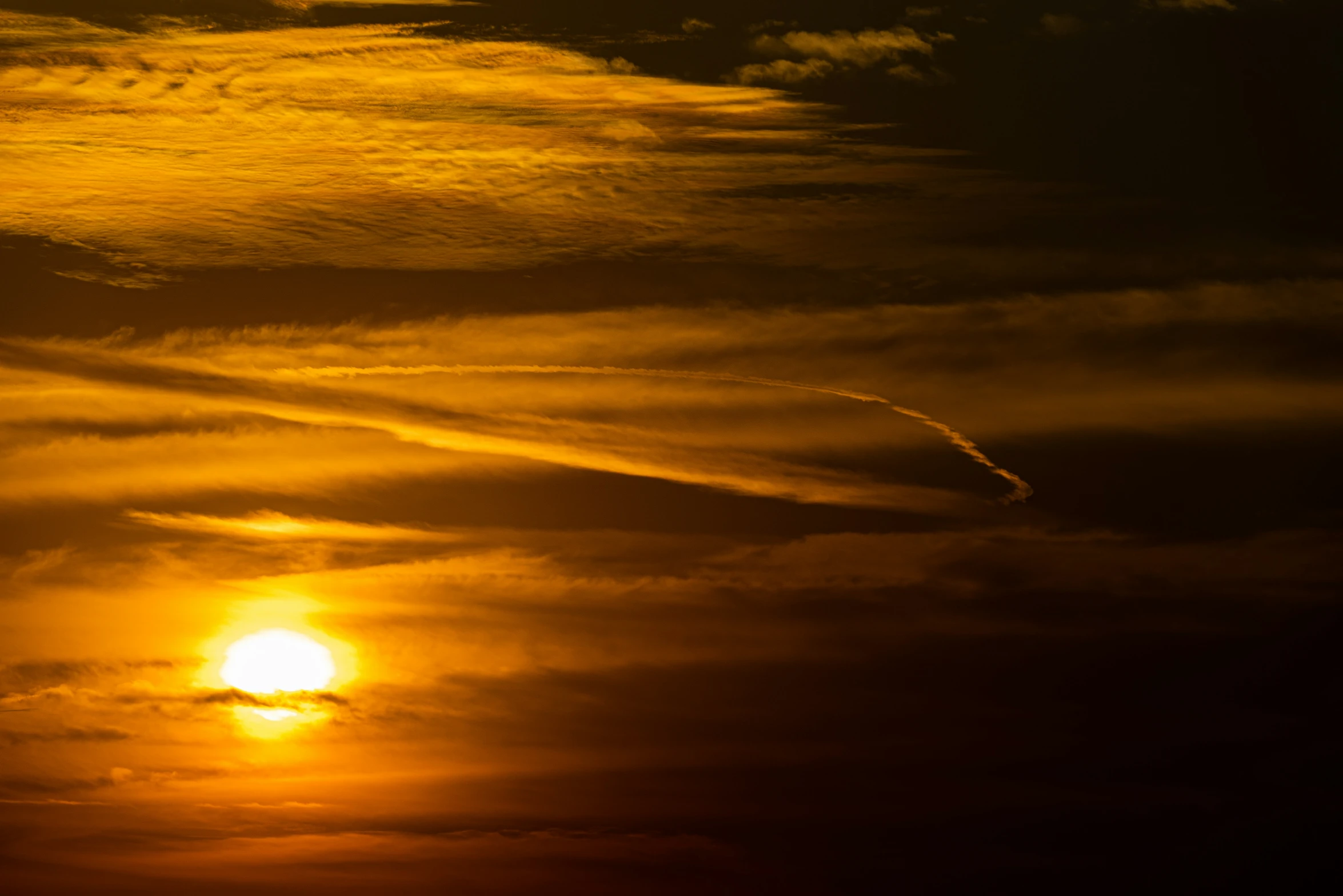 the sky is getting sun - kissed with clouds and a plane