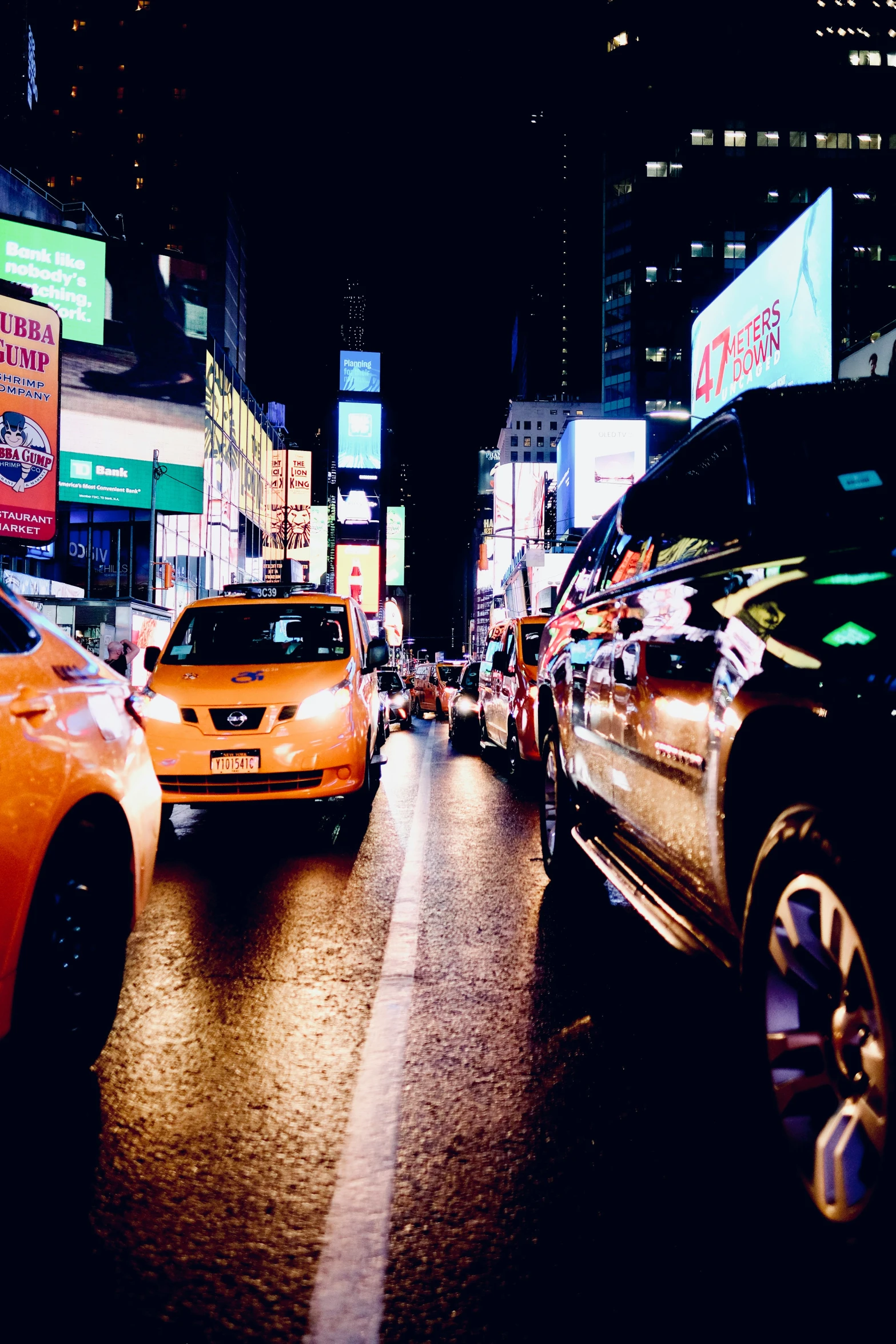 a city street with many vehicles and billboards