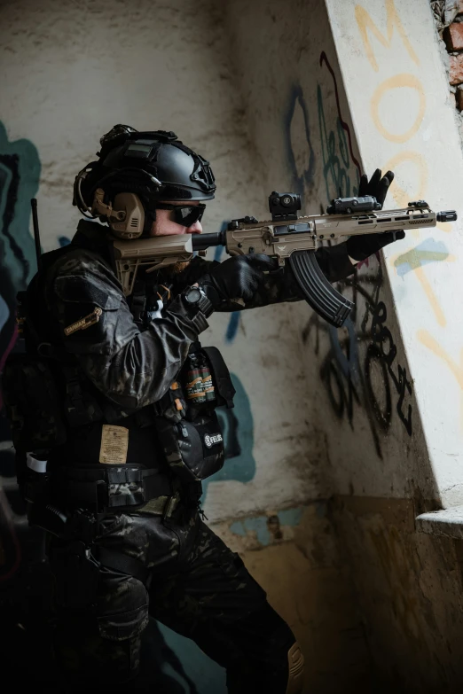 a soldier with an automatic rifle in a graffiti - covered alley