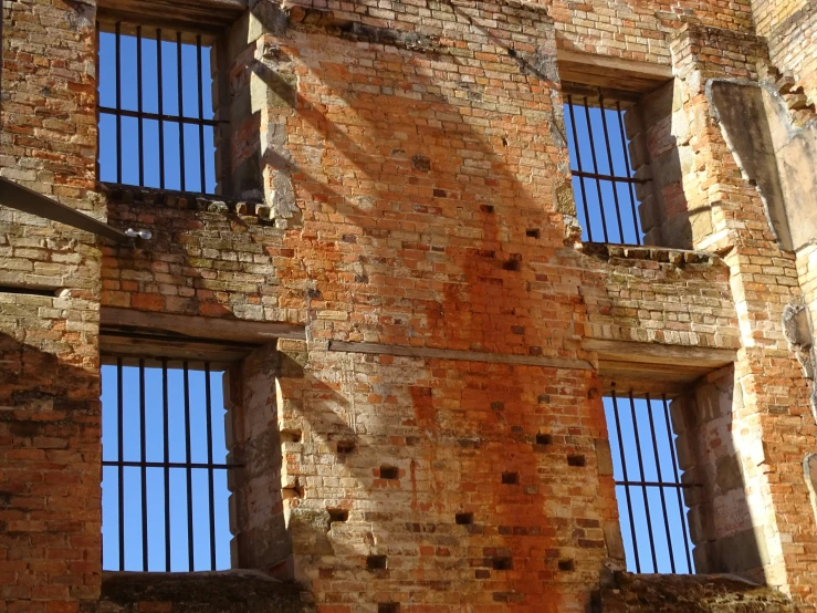 brick building with several windows, and bars on each