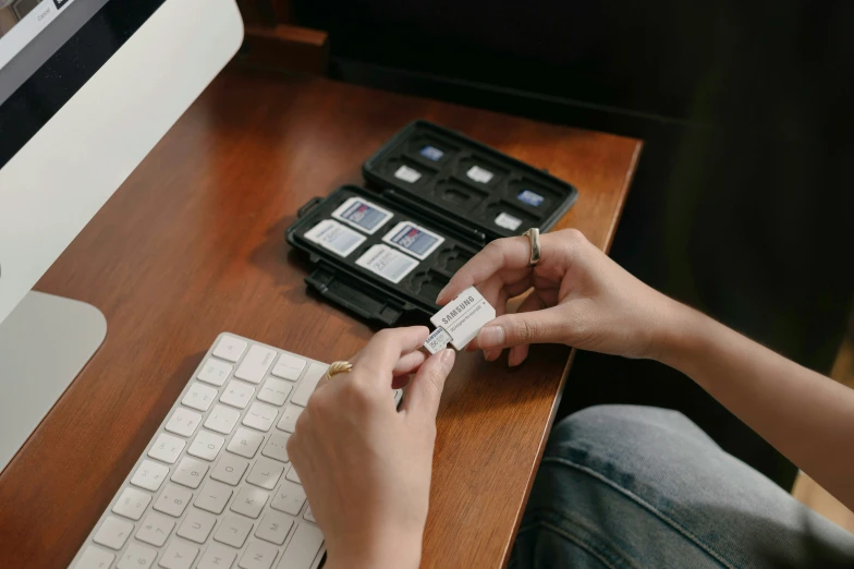 woman working at a computer with a card next to her