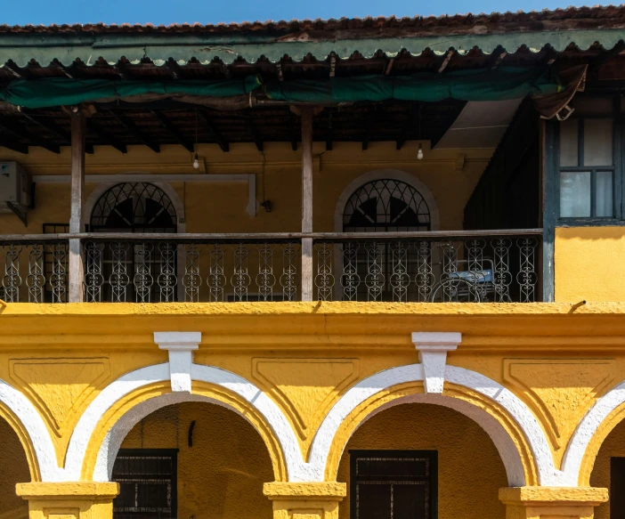 the building has arches on the sides and a balcony