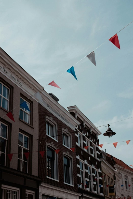 multicolored kites in the air over a building