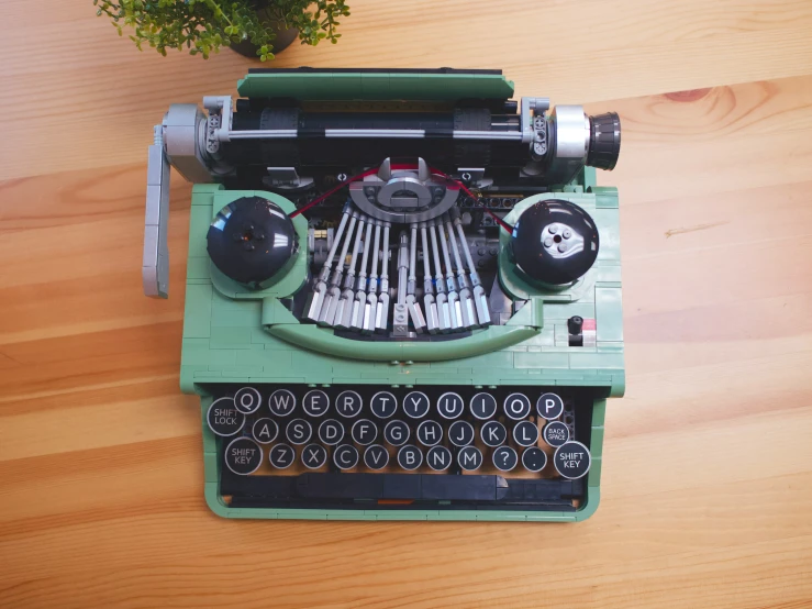 an old green typewriter with a green table and potted plant
