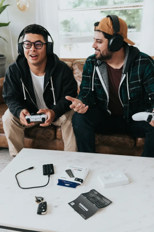 two men are sitting on the couch playing a video game