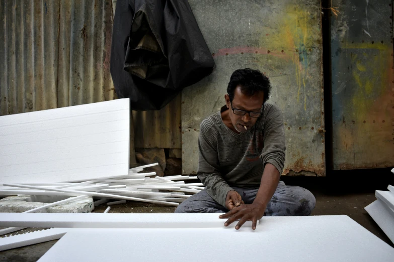 a man looking at some white papers on the ground