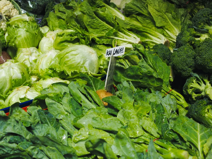 an assortment of greens in boxes on display at a market