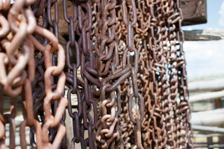 old rusty chains are hanging outside a wooden structure