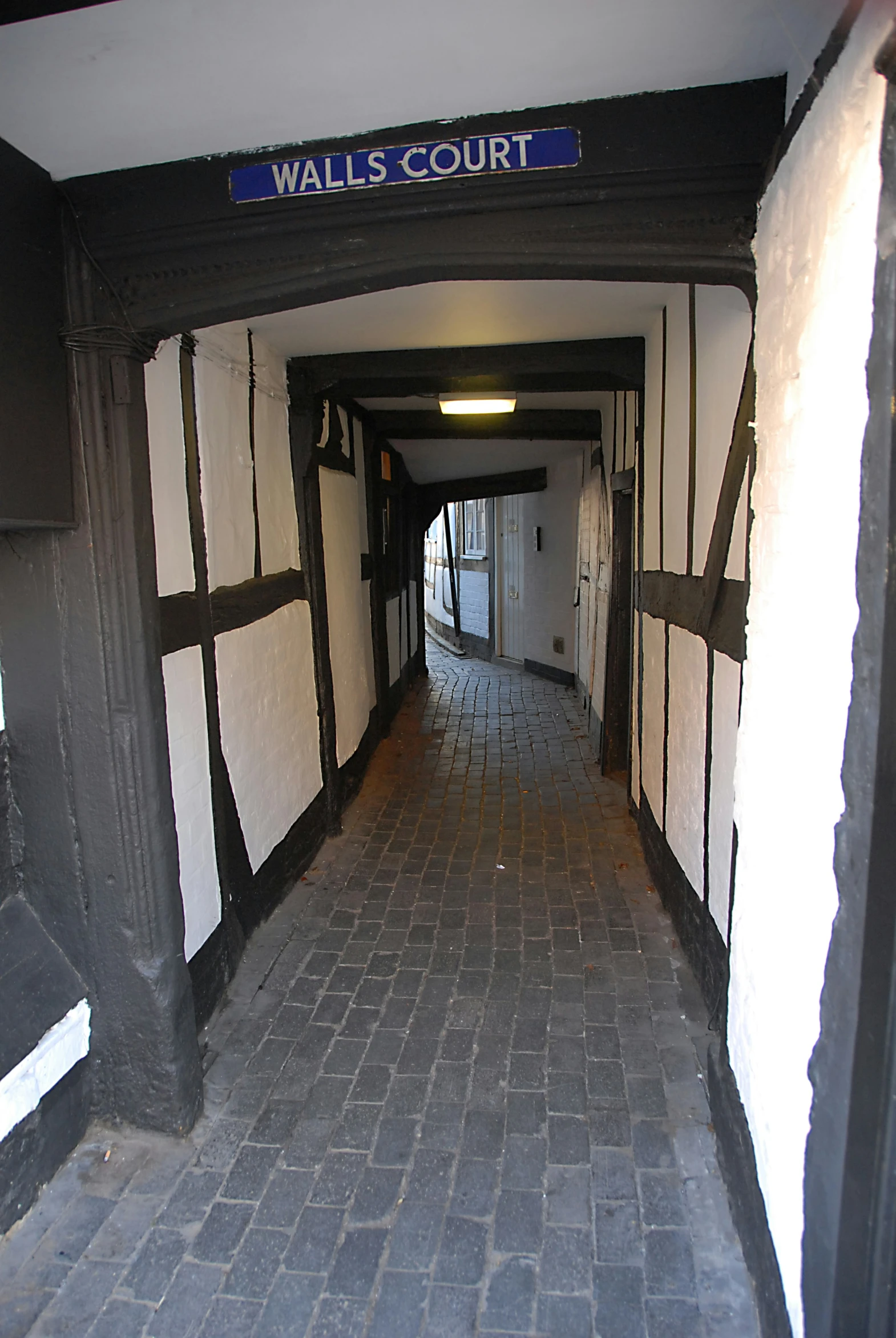a narrow hallway has brick and stone floors