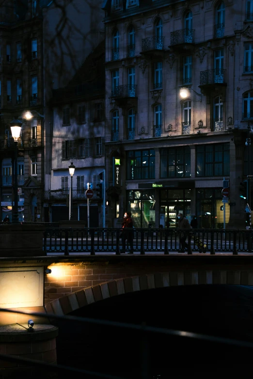 people walking on a bridge in the dark by night