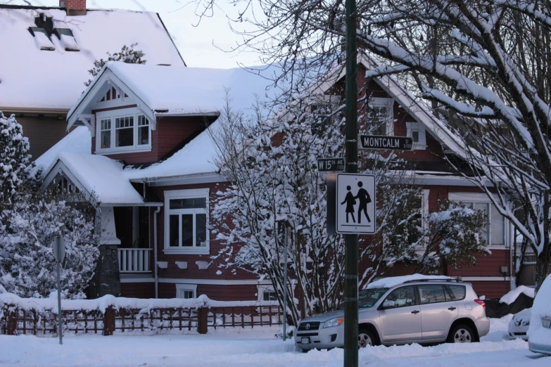 a snow covered road and a house with snow piled up in front of it